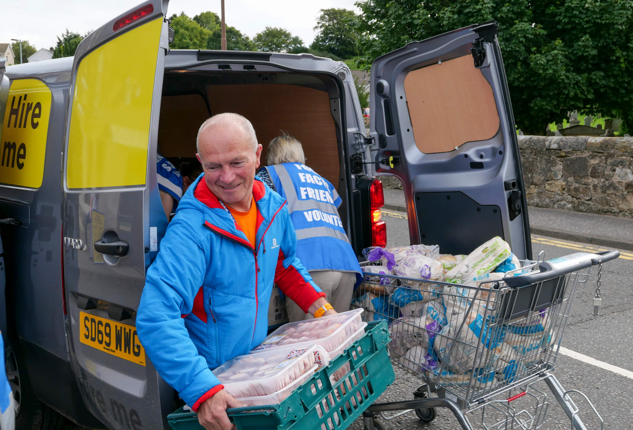 Volunteers loading food into a van 